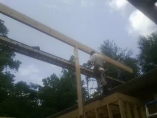 Carpenter setting a ridge beam over a new addition frame — Ice Dam Removal by Roofing Brothers in Huntington